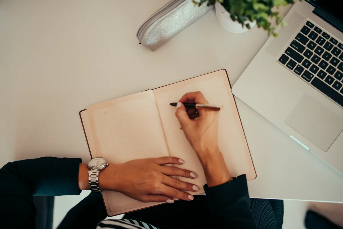 Writing desk with notebook and laptop